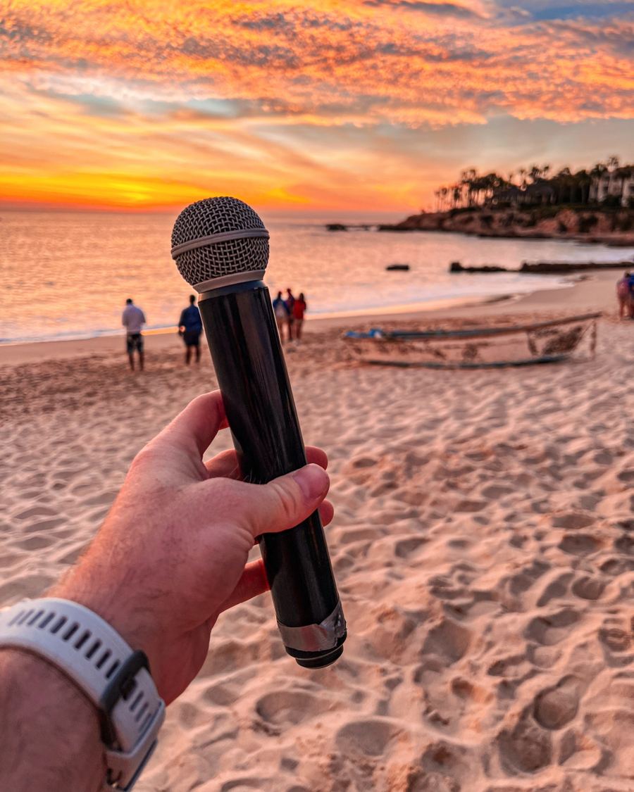 A microphone held up on a beach at sunset